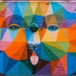 Vibrant geometric mural of a bear on a brick wall in London, showcasing diverse colors and artistic flair.