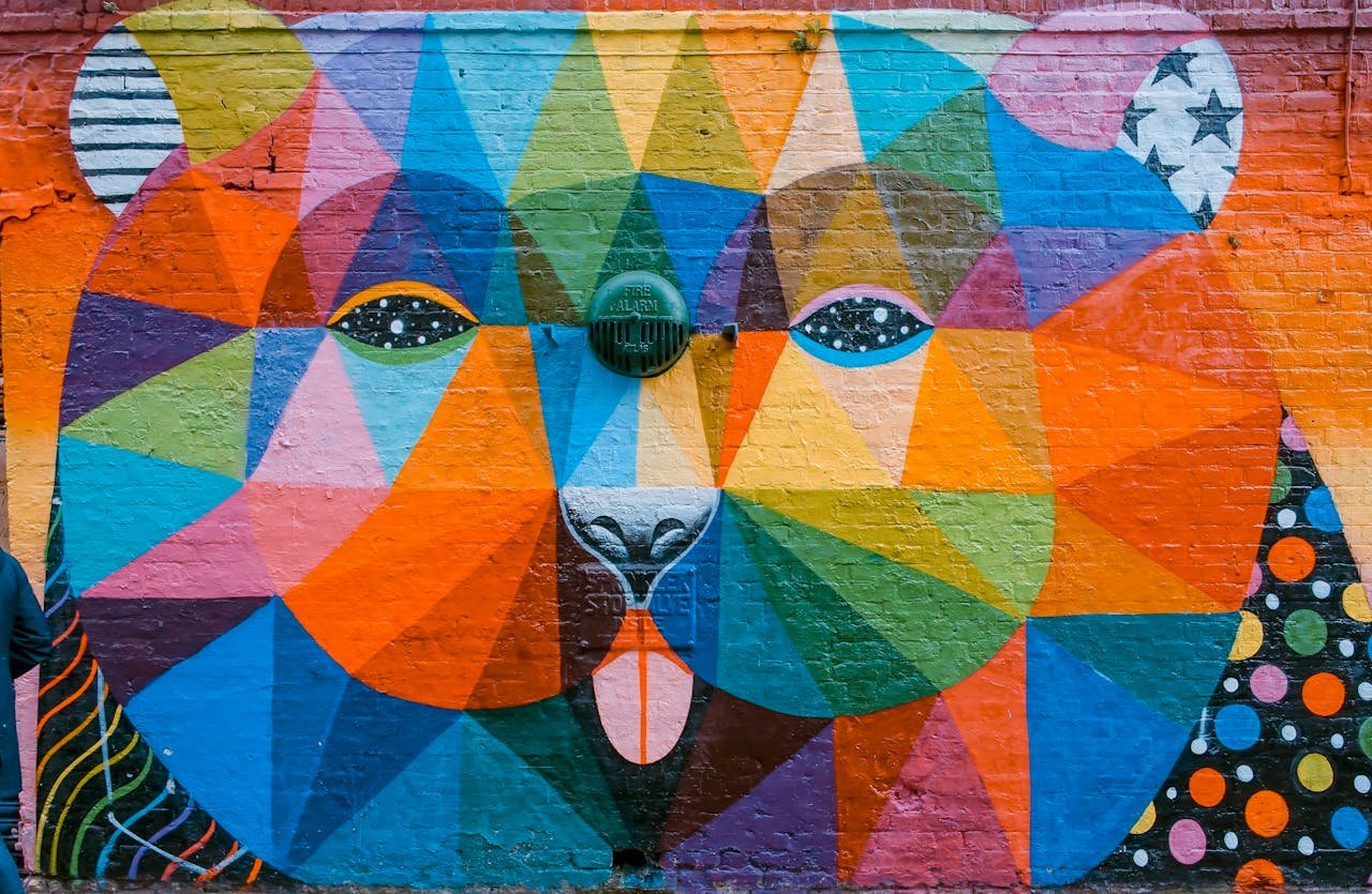 Vibrant geometric mural of a bear on a brick wall in London, showcasing diverse colors and artistic flair.